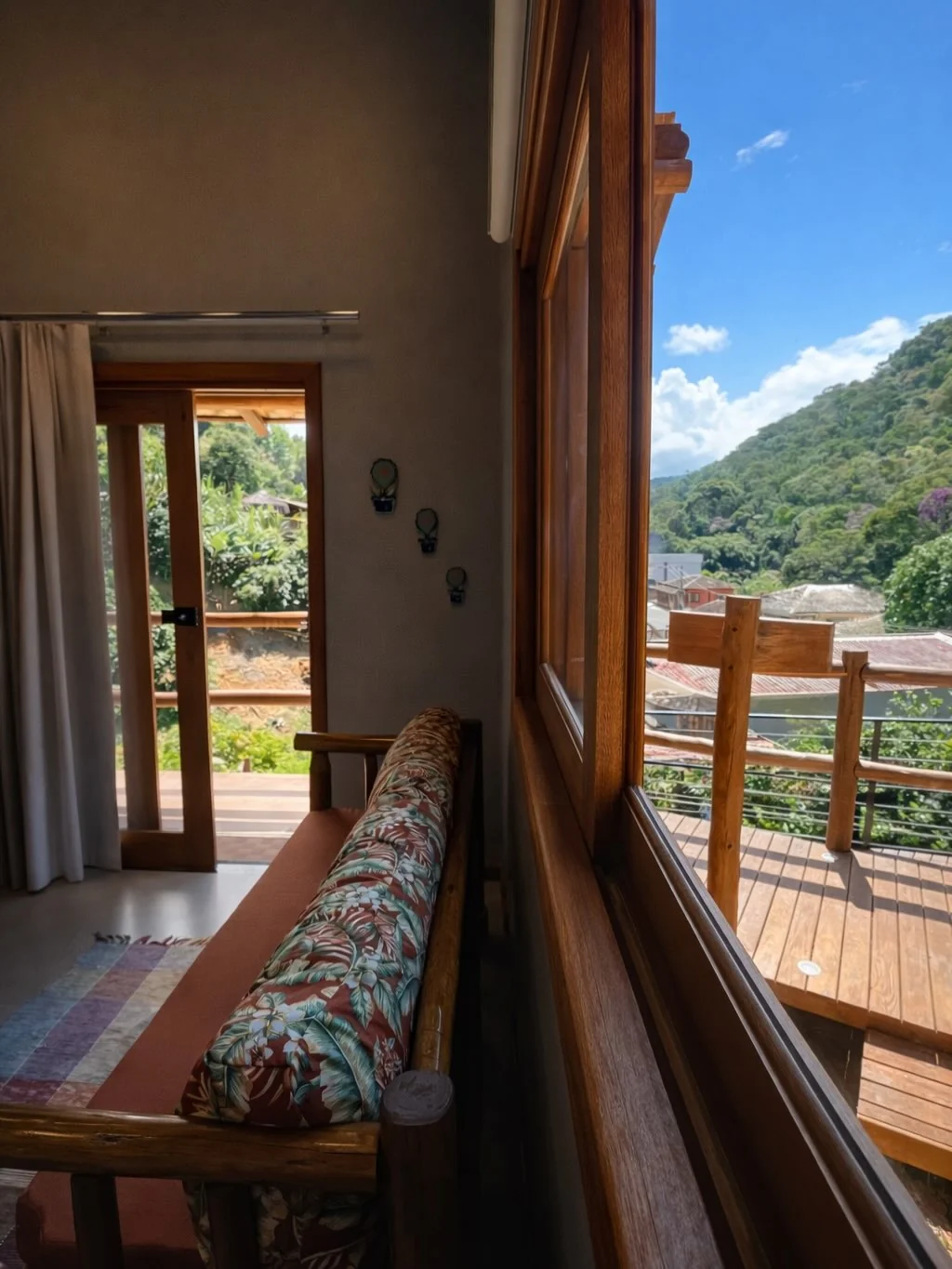 Sala de estar de um chalé do Vila Florença com vista pra serra de Santa Teresa
